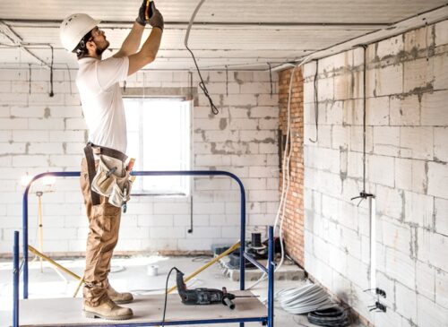 electrician-installer-with-tool-his-hands-working-with-cable-construction-site electrician-installer-with-tool-his-hands-working-with-cable-construction-site