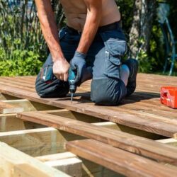 deck-construction-builder-hand-with-electric-screwdriver-installing-impregnated-wooden-boards_664057-14811