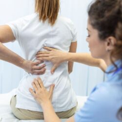 physiotherapist-doing-healing-treatment-womans-back-back-pain-patient-treatment-medical-doctor-massage-therapistoffice-syndrome